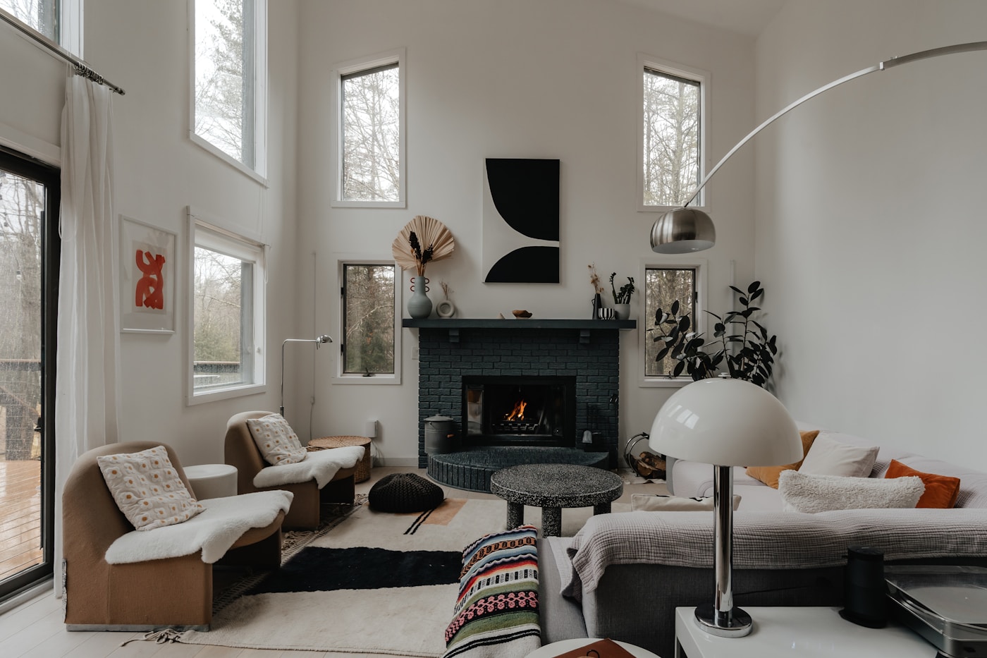 A light-filled living room with a black fireplace and warm natural textures