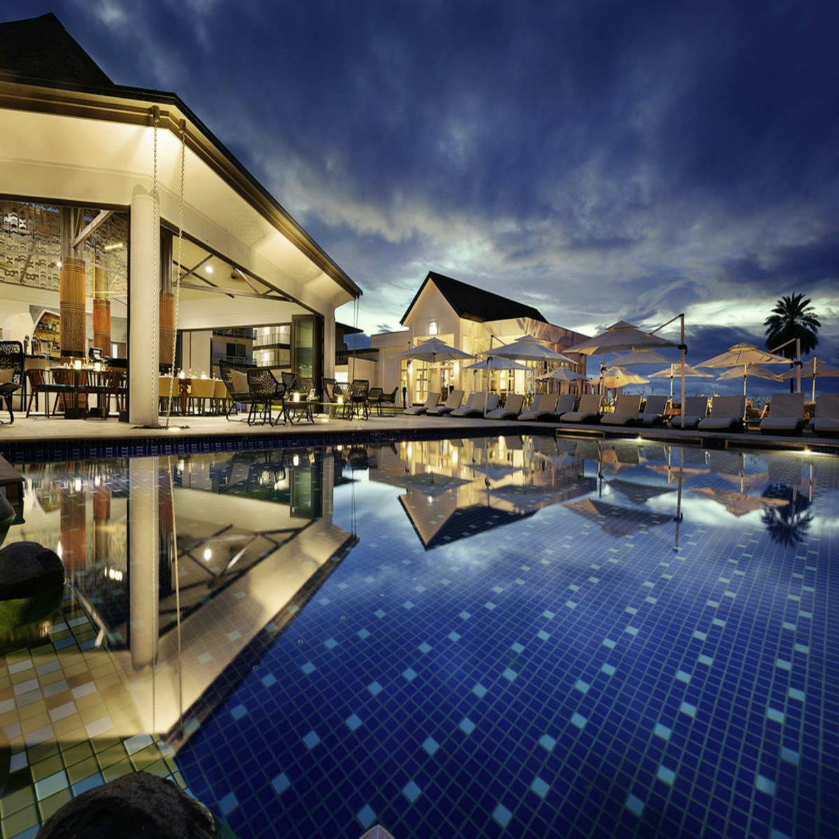 A resort swimming pool surrounded by palms